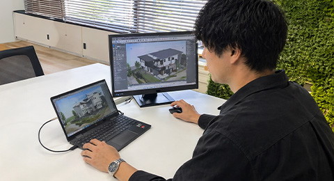3Dパースを確認するスタッフ